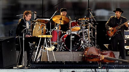Bob Dylan, left, plays the keyboards with his band and sings a sweet melody as the final act of SunFest 2003 on the Washington