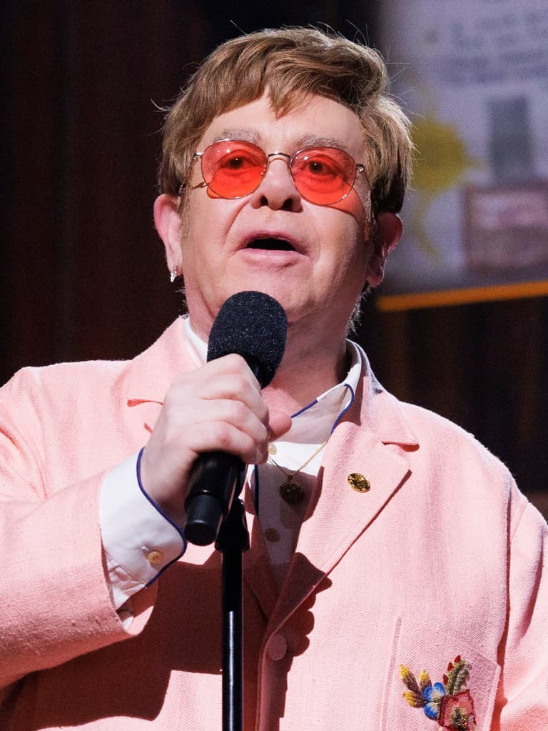 elton john holding microphone