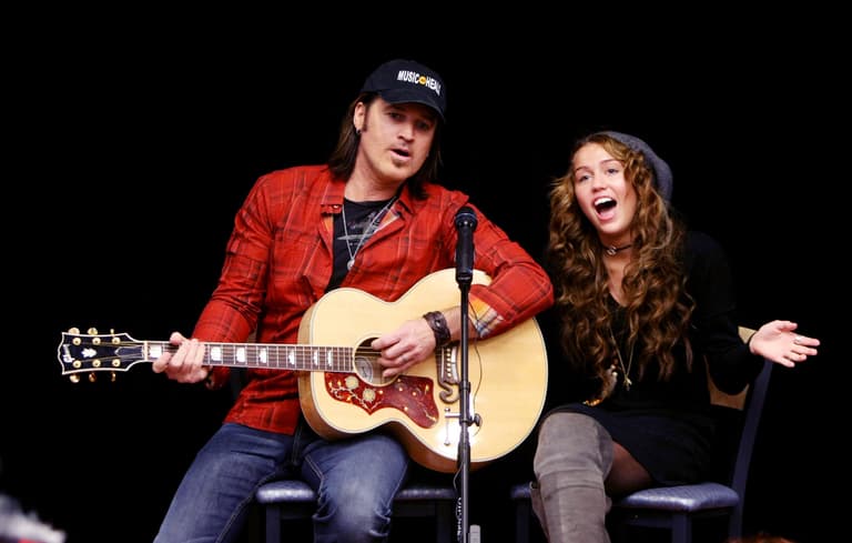 Billy Ray Cyrus, left, and his daughter, Miley Cyrus, sing Christmas songs for the patients during a surprise visit to Monroe