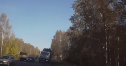 car avoids logging truck