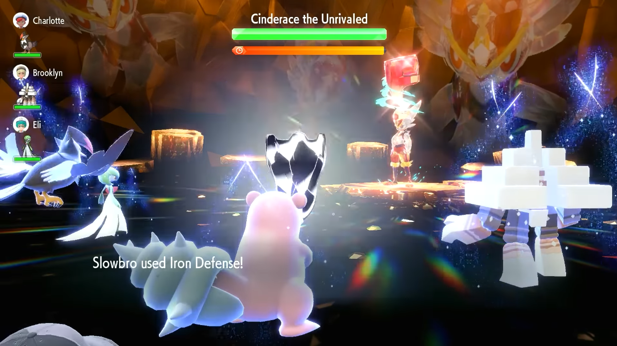 A Slowbro uses Iron Defense in a Tera Raid Battle against a Tera-Fighting Cinderace. A Gardevoir, Staraptor, and Garganacl are also battling via Pokémon Scarlet & Violet (2022), Nintendo
